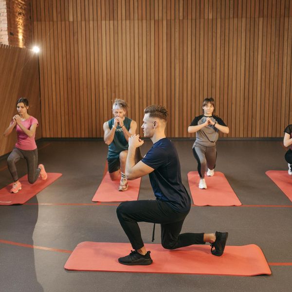 Group of diverse people smiling during a calm cardio workout session indoors.